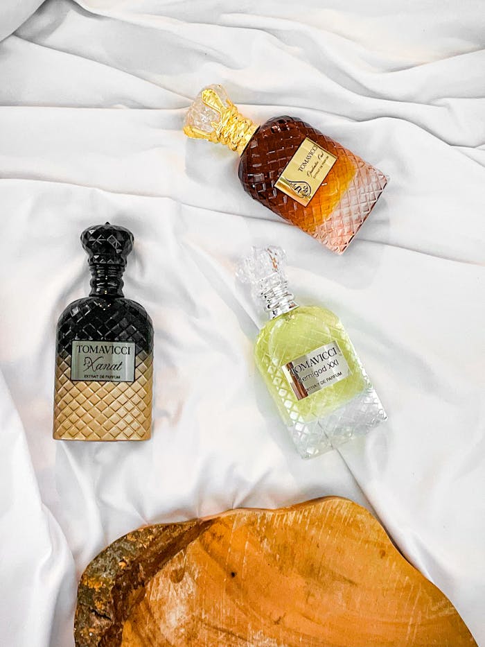 services-03 Three luxurious diamond-cut perfume bottles on white fabric, exuding elegance and style.