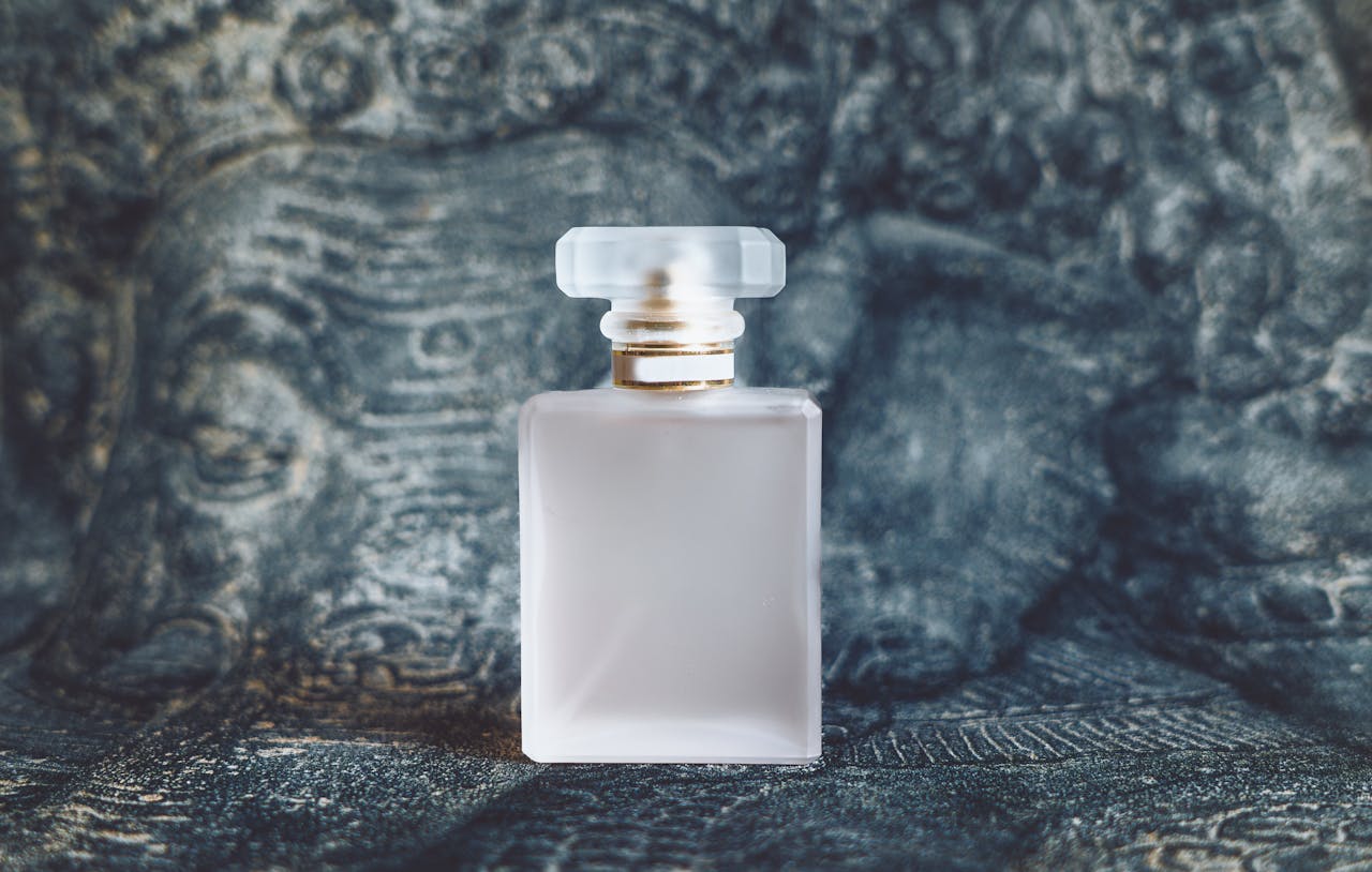 get-in-touch Minimalist square perfume bottle on textured artistic background capturing elegance and luxury.