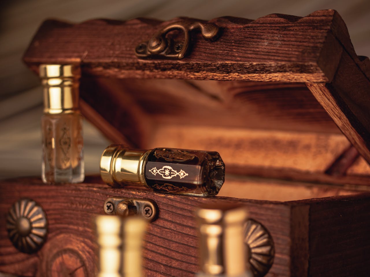 services-bg Close-up of antique perfume bottles in an open rustic wooden box, showcasing elegance and luxury.